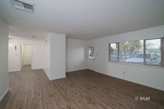 315 East Robertson Road Ridgecrest, CA 93555 - Photo 2 of 27 an empty room with wooden floor and windows