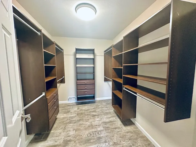 a view of walk in closet with clothes and shoes