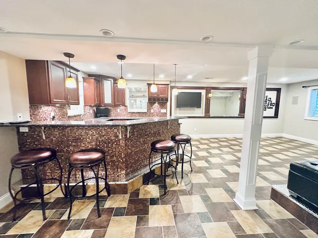 a kitchen with a sink and chairs