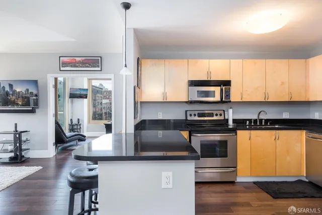 a kitchen with stainless steel appliances granite countertop a stove a sink and a microwave