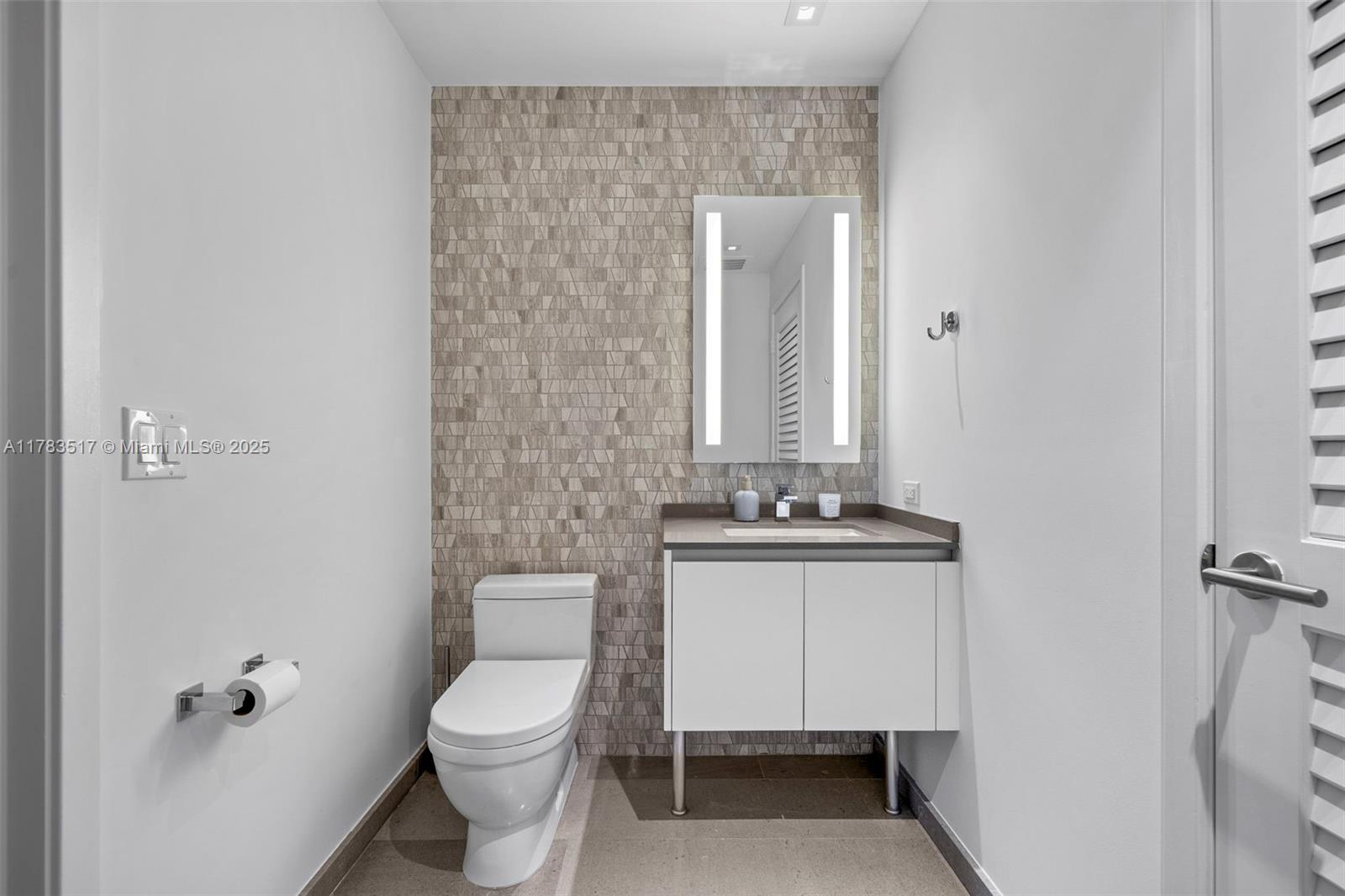 88 Southwest 7th Street, Unit 809 Miami, FL 33130 - Photo 22 of 45 a bathroom with a toilet a sink and mirror