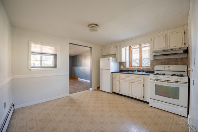 a kitchen with white cabinets and white appliances