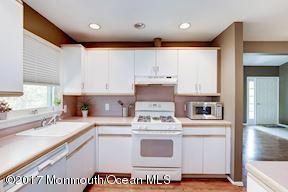 21 Maple Lane, Unit B Brielle, NJ 08730 - Photo 19 of 51 a kitchen with kitchen island granite countertop a sink cabinets and wooden floor
