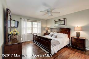 21 Maple Lane, Unit B Brielle, NJ 08730 - Photo 22 of 51 a bedroom with a bed and a chandelier