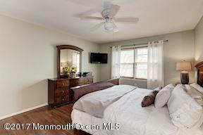 21 Maple Lane, Unit B Brielle, NJ 08730 - Photo 23 of 51 a bedroom with a bed and a chandelier