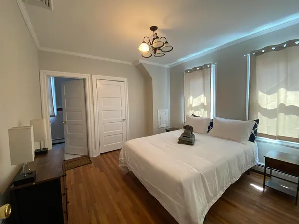 a bedroom with a bed and a chandelier