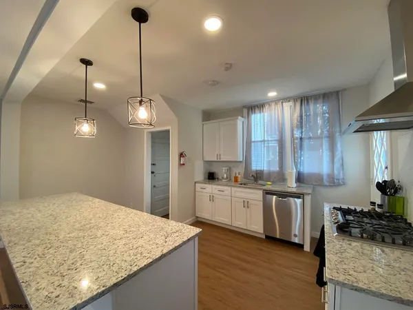 a kitchen with stainless steel appliances granite countertop sink stove and refrigerator