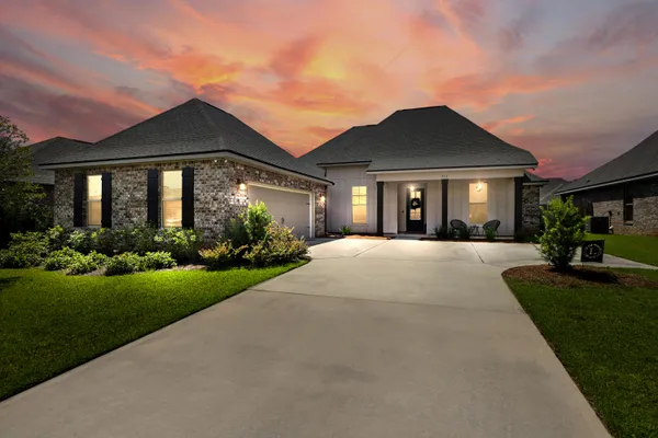a front view of a house with yard and green space