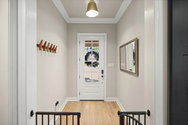 a kitchen with a refrigerator a stove and white cabinets with wooden floor