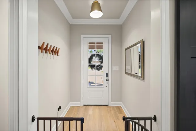 a kitchen with a refrigerator a stove and white cabinets with wooden floor