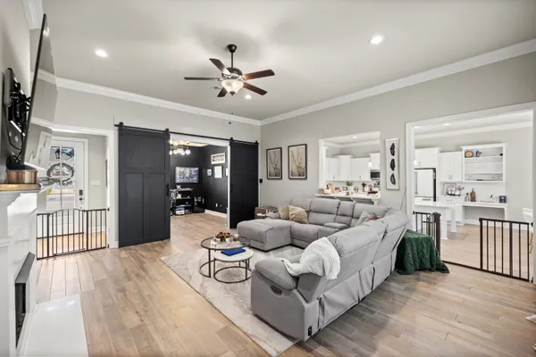 a kitchen with stainless steel appliances a stove a sink dishwasher a refrigerator white cabinets and wooden floor