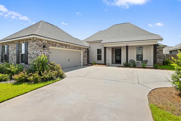 a front view of a house with a garden