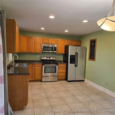 a kitchen with stainless steel appliances a refrigerator and a stove top oven