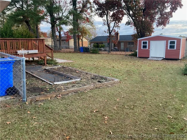 a front view of house with yard seating and trees in the background