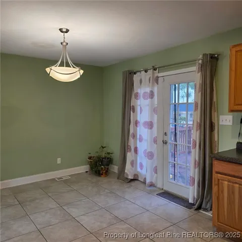 a view of a livingroom with a chandelier wooden floor and a chandelier