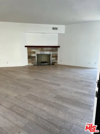 a view of an empty room with a fireplace and a window