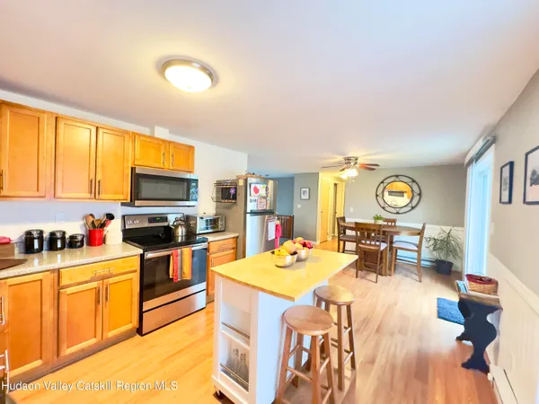 a open kitchen with stainless steel appliances kitchen island granite countertop a stove and a refrigerator