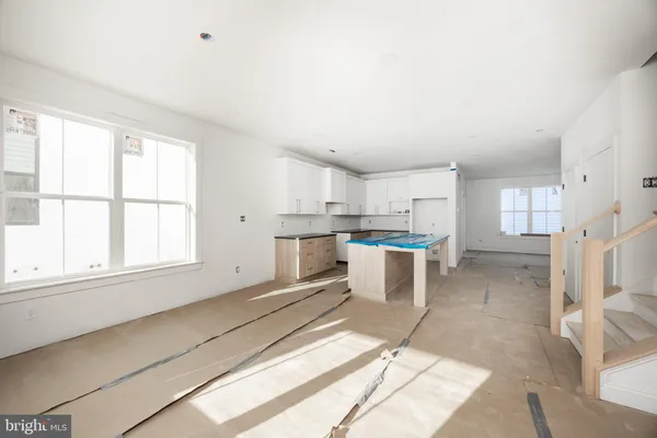 a open kitchen with white cabinets and white appliances