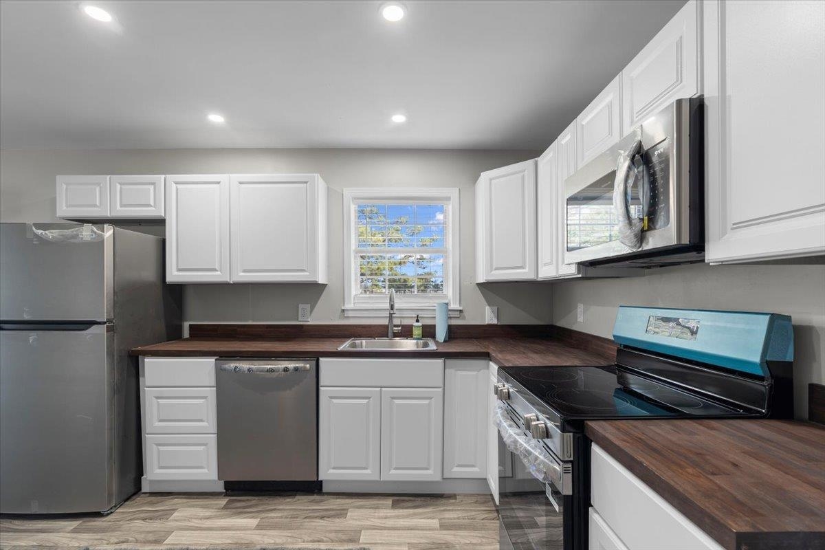 2030 South Main Street Covington, TN 38019 - Photo 8 of 27 a kitchen with stainless steel appliances granite countertop a stove a sink and a microwave