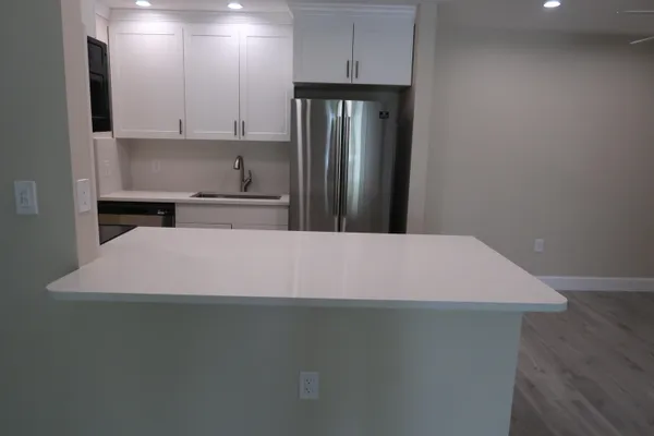 a kitchen with kitchen island a stove a sink and a refrigerator