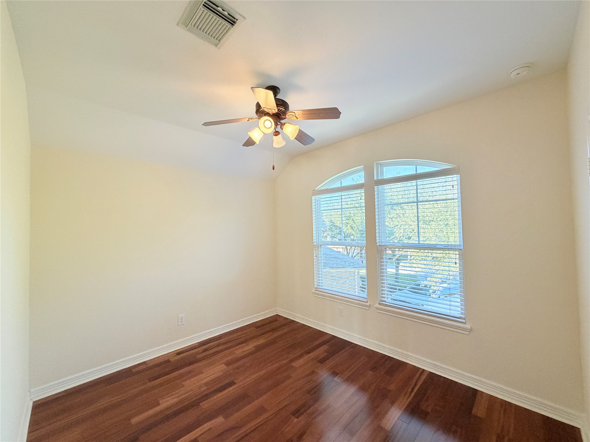 28015 Silverstream Court Fulshear, TX 77441 - Photo 31 of 33 an empty room with wooden floor chandelier fan and windows