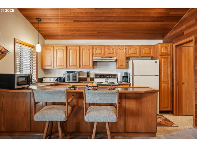 a kitchen with stainless steel appliances granite countertop a sink refrigerator and cabinets