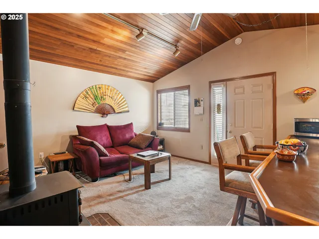 a living room with furniture kitchen view and a large window