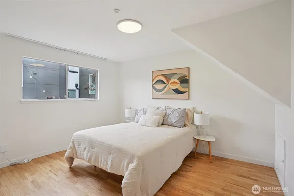 a bedroom with a bed and painting on the wall