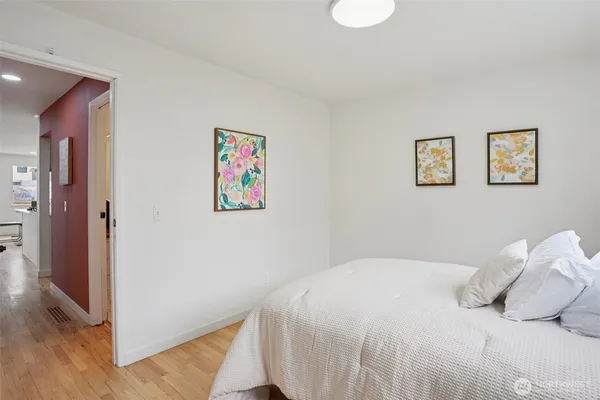 a bedroom with a bed and a painting on the wall
