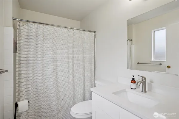 a bathroom with a sink a toilet and shower curtain