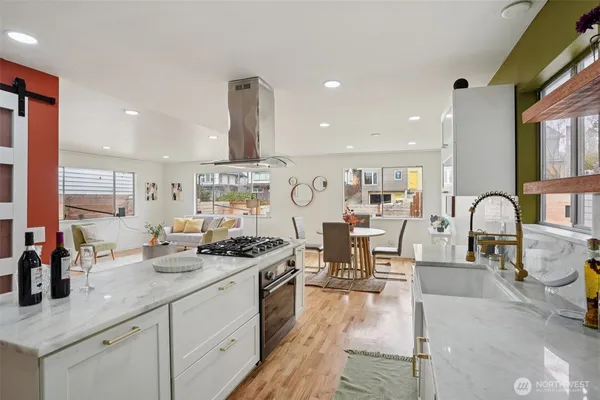a large kitchen with stainless steel appliances a large counter top a stove and a sink