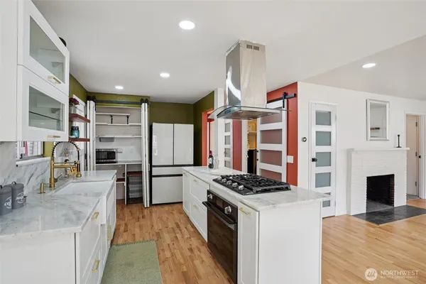 a kitchen with stainless steel appliances kitchen island granite countertop a stove and a sink