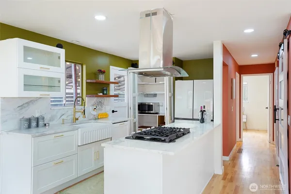 a kitchen with a sink stainless steel appliances a counter top space and cabinets