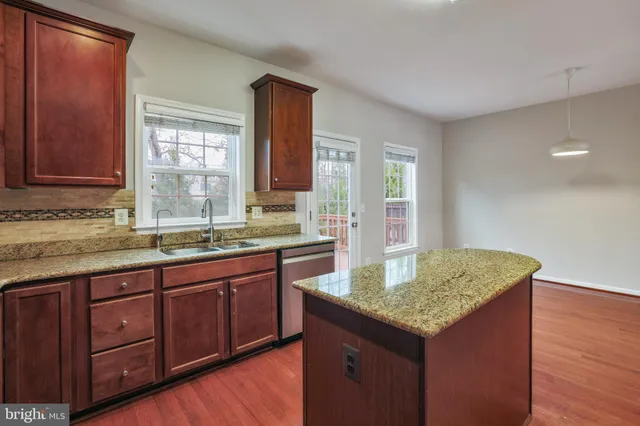 a kitchen with granite countertop kitchen island wooden cabinets granite counter tops and a window
