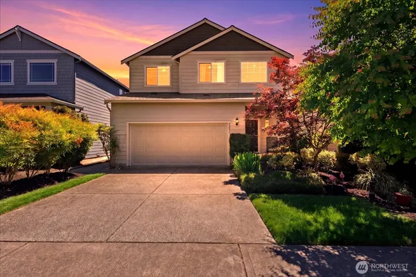 a front view of a house with a yard and garage