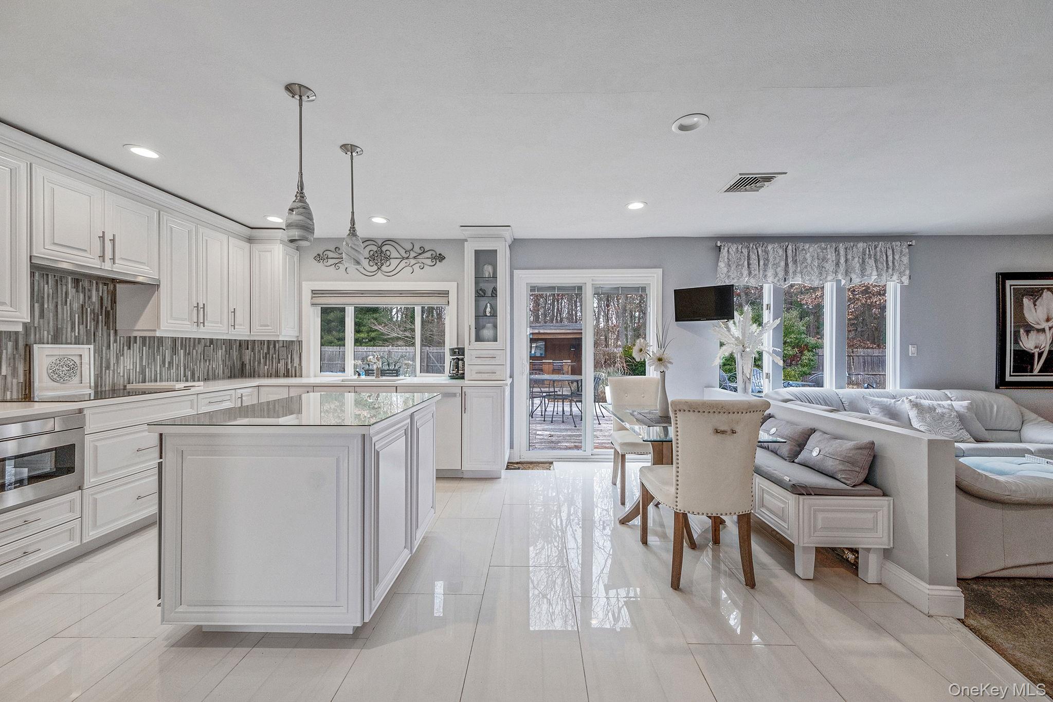 32 San Rafael Avenue Holbrook, NY 11741 - Photo 42 of 44 a large kitchen with kitchen island a large counter top space a sink stainless steel appliances and cabinets