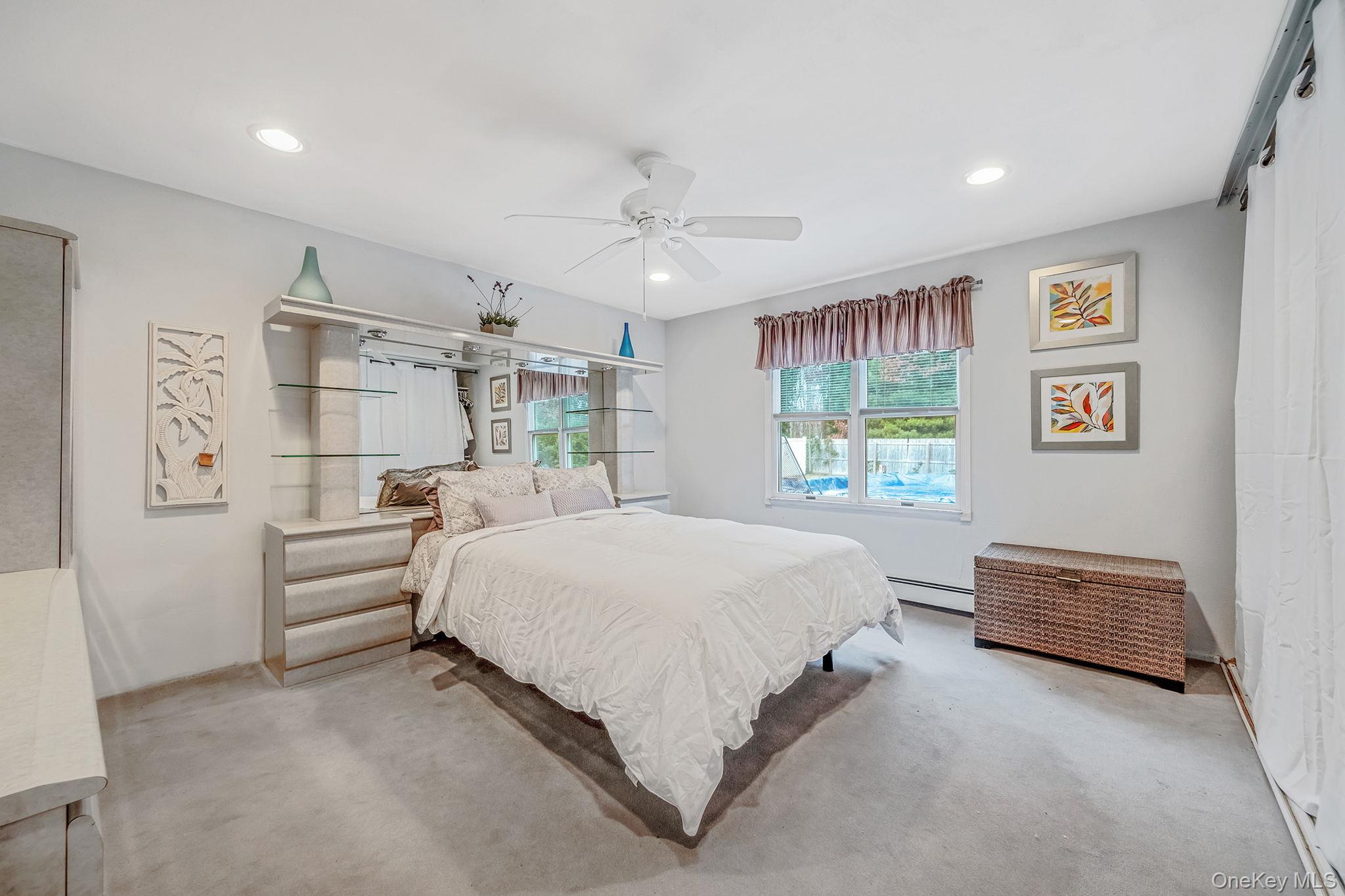 32 San Rafael Avenue Holbrook, NY 11741 - Photo 34 of 44 a spacious bedroom with a bed and a chandelier