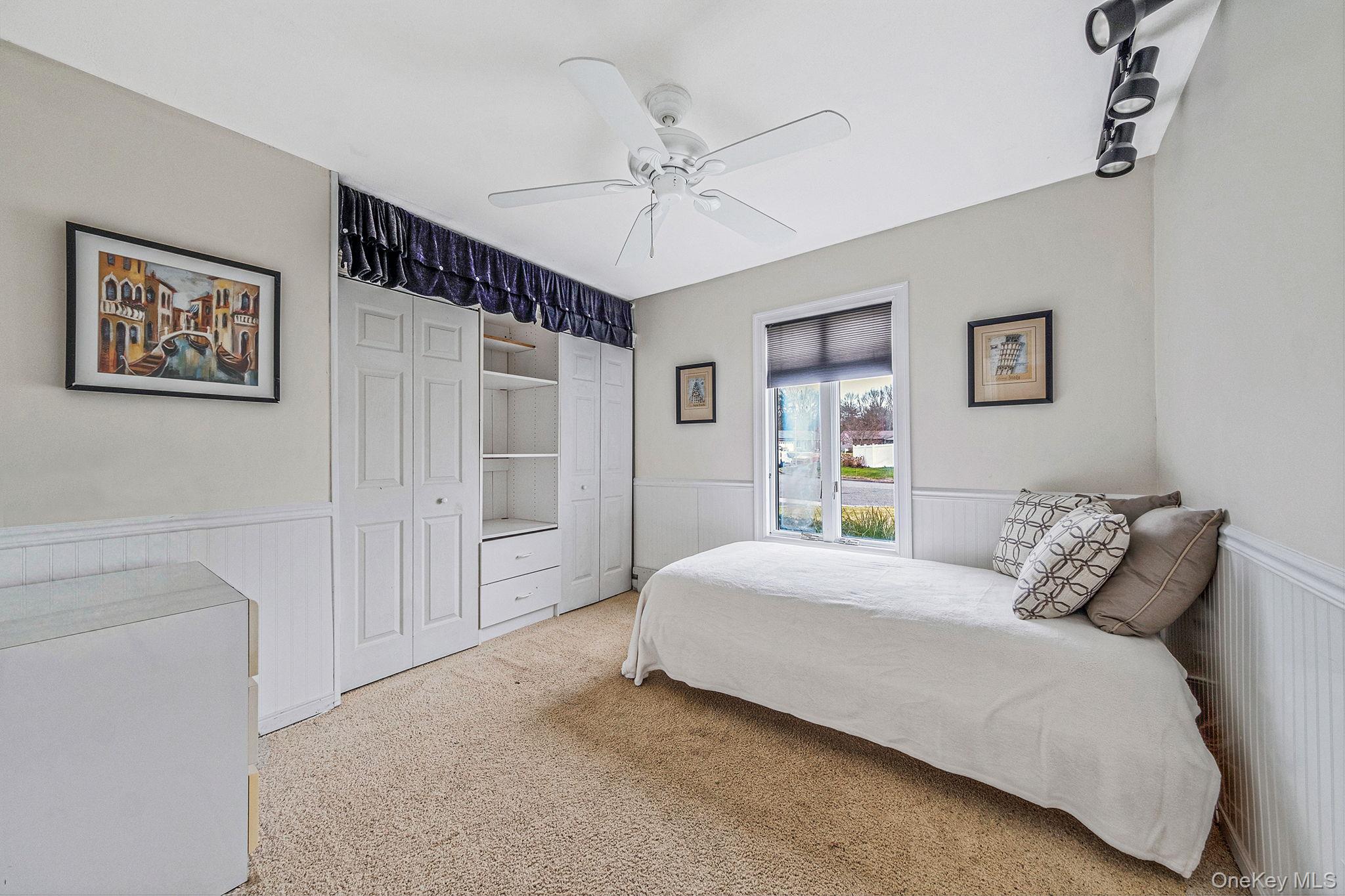 32 San Rafael Avenue Holbrook, NY 11741 - Photo 37 of 44 a bedroom with a large bed and a chandelier