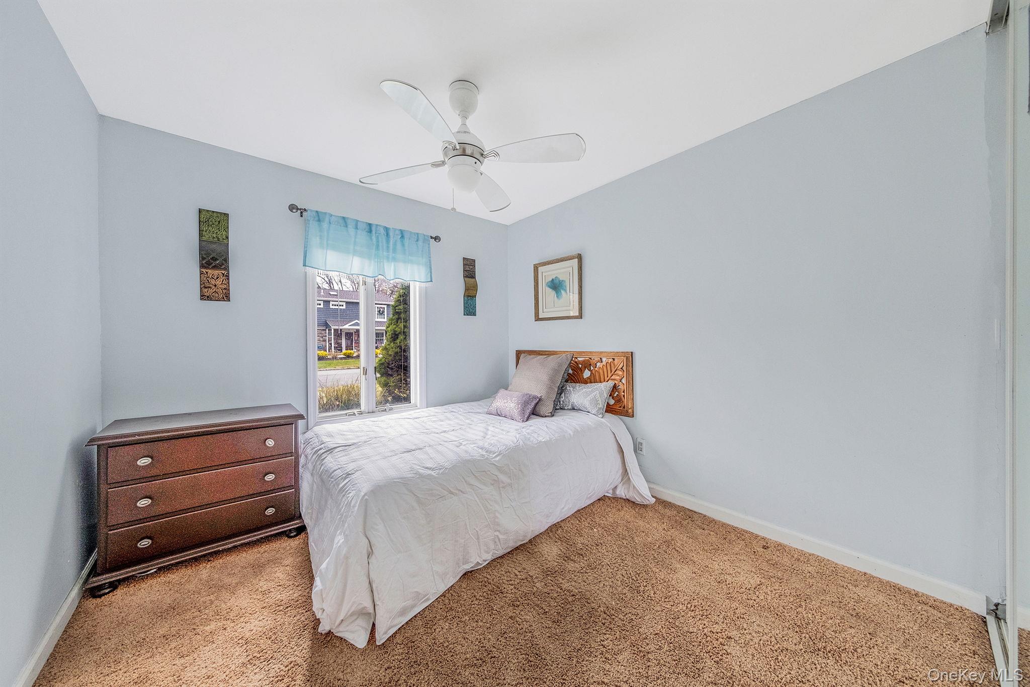 32 San Rafael Avenue Holbrook, NY 11741 - Photo 39 of 44 a bedroom with a bed and a chandelier