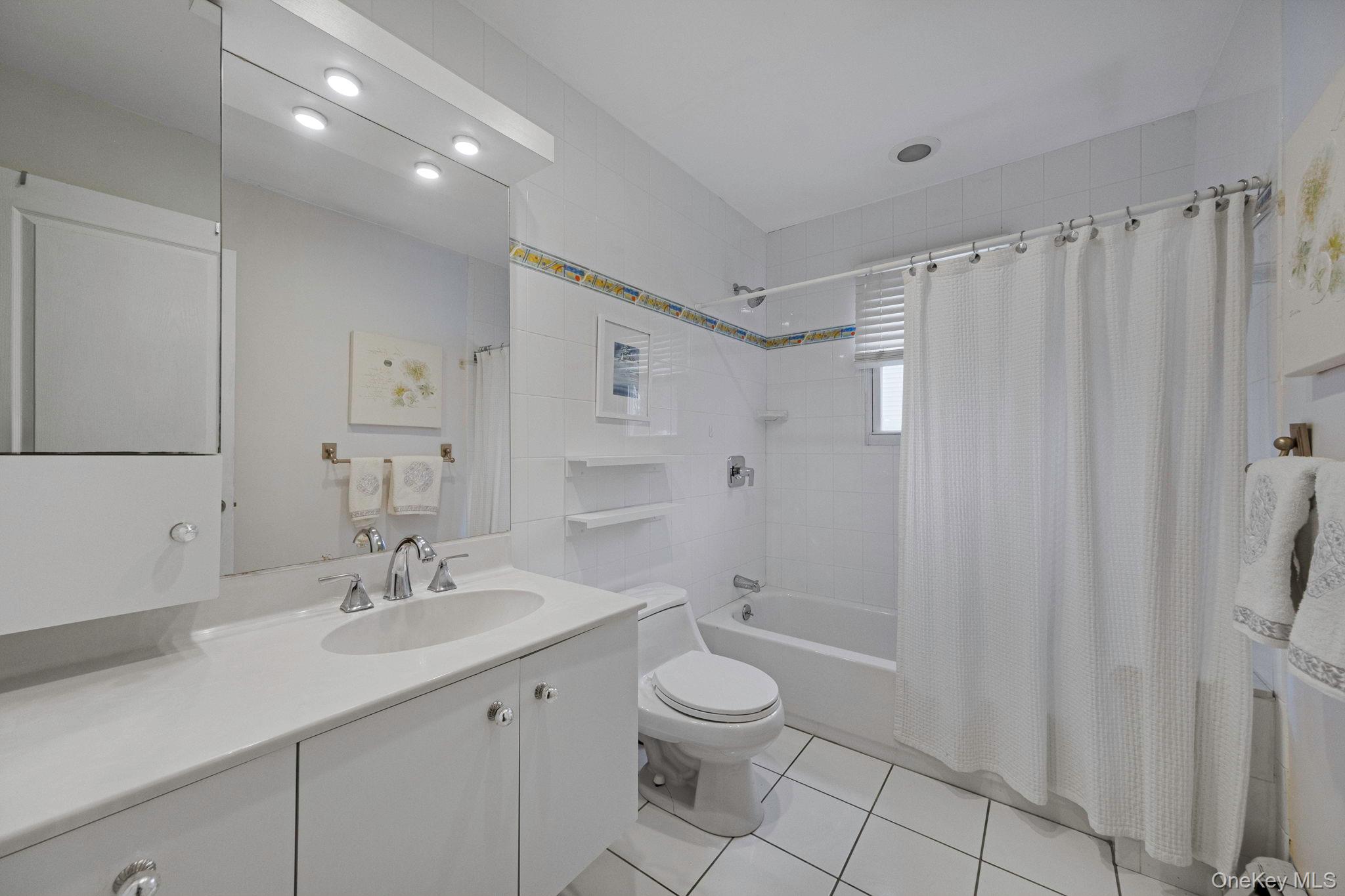 32 San Rafael Avenue Holbrook, NY 11741 - Photo 40 of 44 a bathroom with a toilet a sink a mirror a shower and vanity