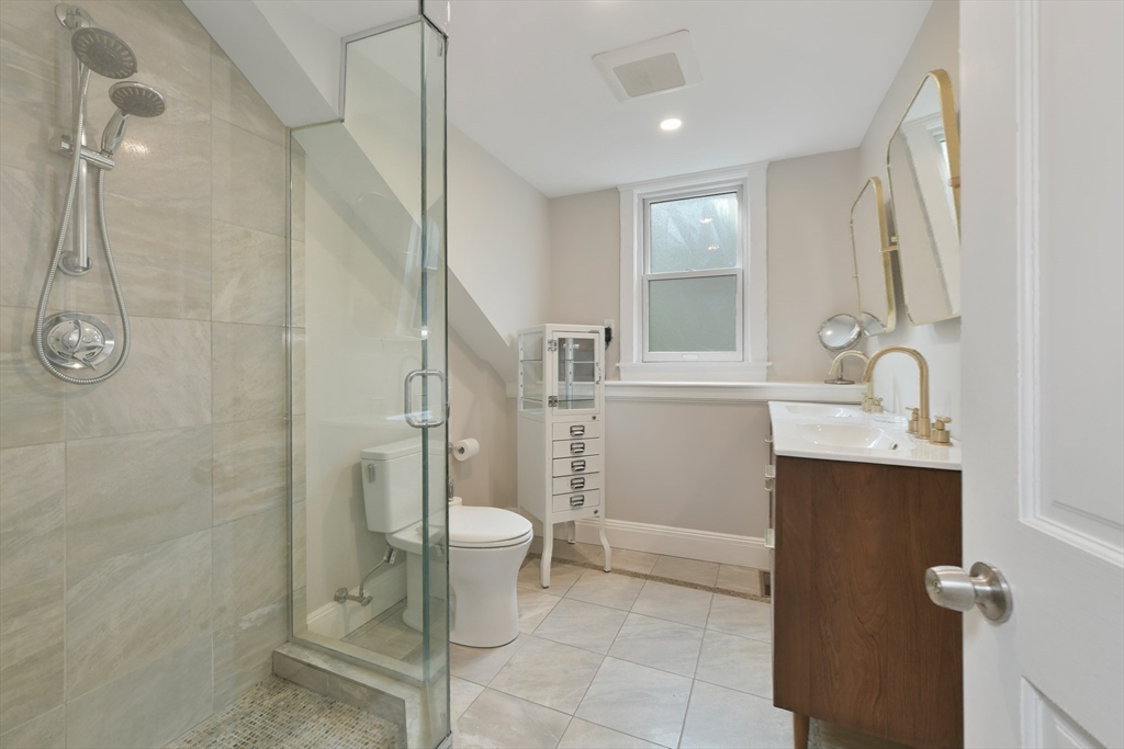 6 Strong Place Boston, MA 02114 - Photo 17 of 25 a bathroom with a granite countertop sink toilet a mirror and shower
