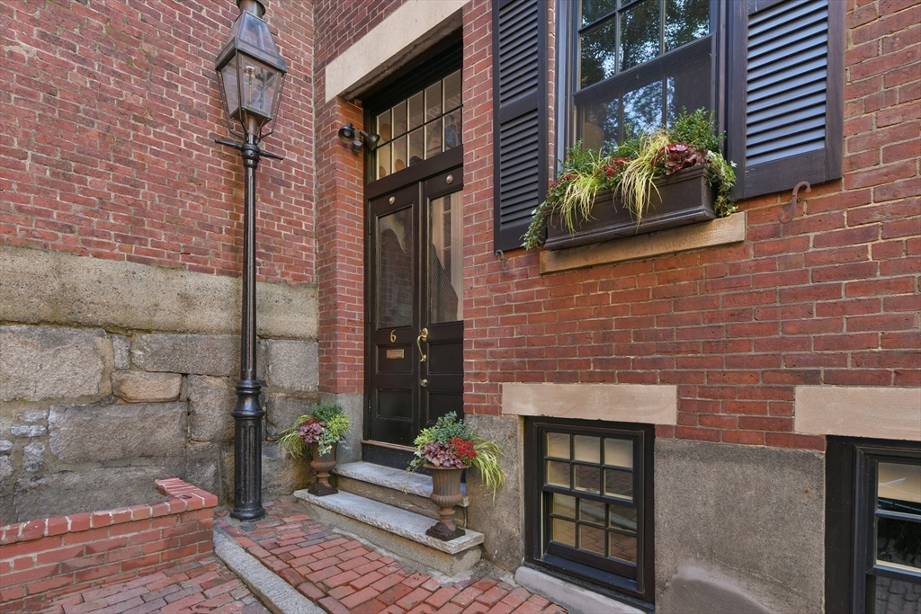 6 Strong Place Boston, MA 02114 - Photo 2 of 25 a brick building with a bench and a potted plant