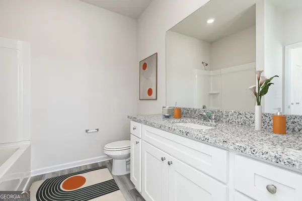 a spacious bathroom with a granite countertop toilet and a sink