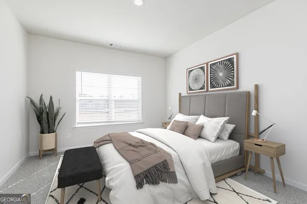 a bedroom with a bed and painting on the wall