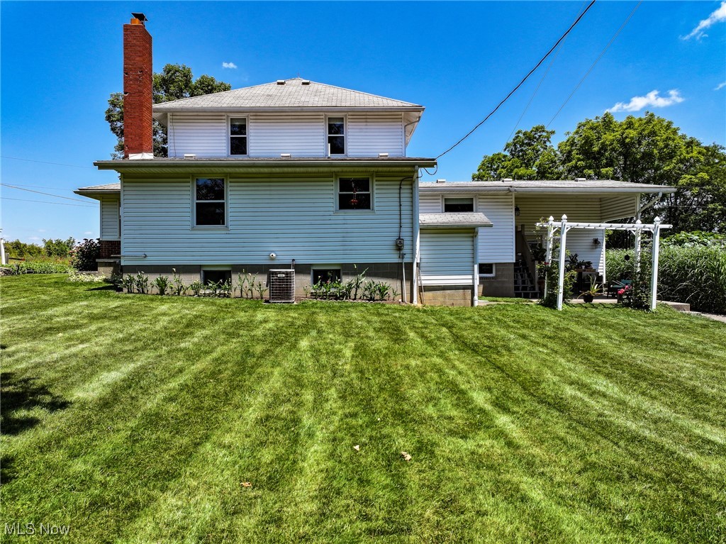 4003 Ragersville Road Southwest Baltic, OH 43804 - Photo 4 of 8 Back of property with cooling unit and a lawn