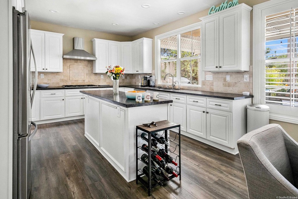 6425 Topmast Drive Carlsbad, CA 92011 - Photo 8 of 32 a kitchen with stainless steel appliances granite countertop wooden cabinets a sink dishwasher a stove and a refrigerator with wooden floor