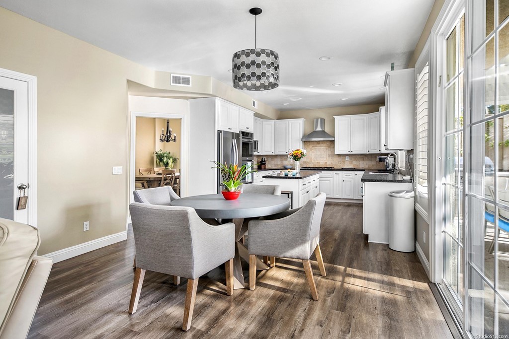 6425 Topmast Drive Carlsbad, CA 92011 - Photo 10 of 32 a kitchen with stainless steel appliances a dining table chairs and a refrigerator