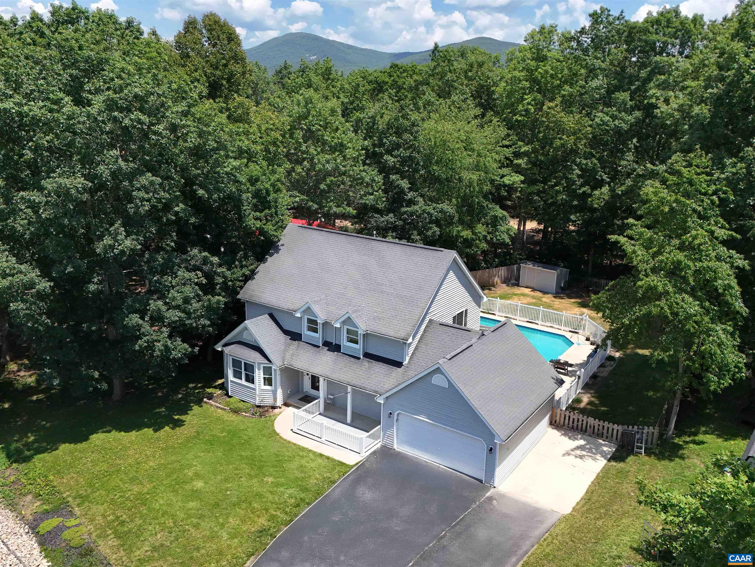 an aerial view of a house with swimming pool and garden