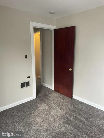 an empty room with closet and mirror
