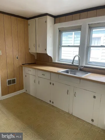 a kitchen with granite countertop white cabinets and a sink